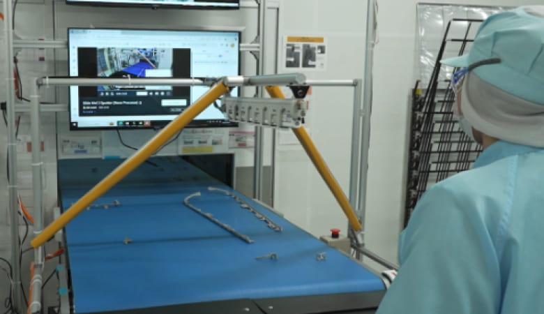 明和工業株式会社の作業場にディスプレイを設置し、QRコードで即座に動画マニュアルを呼び出せる仕組み